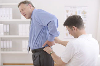 Physiotherapy: Physiotherapist examining senior man