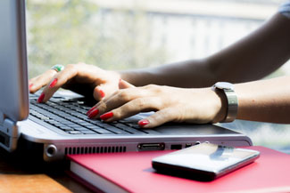 Hands of a businesswoman typing on a computer keyboard
