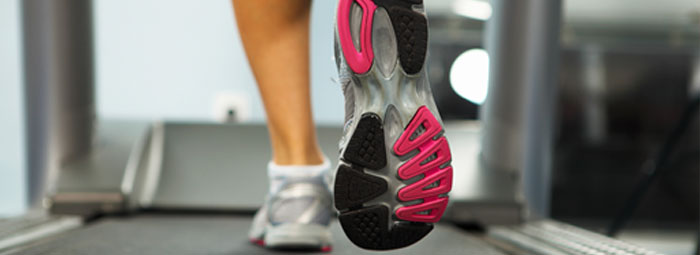 Runner feet running on road closeup on shoe. woman fitness sunri